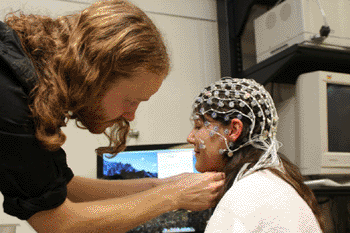 Image: Dr. Damien Cruse demonstrates the EEG method used to detect consciousness (Photo courtesy of UWO).
